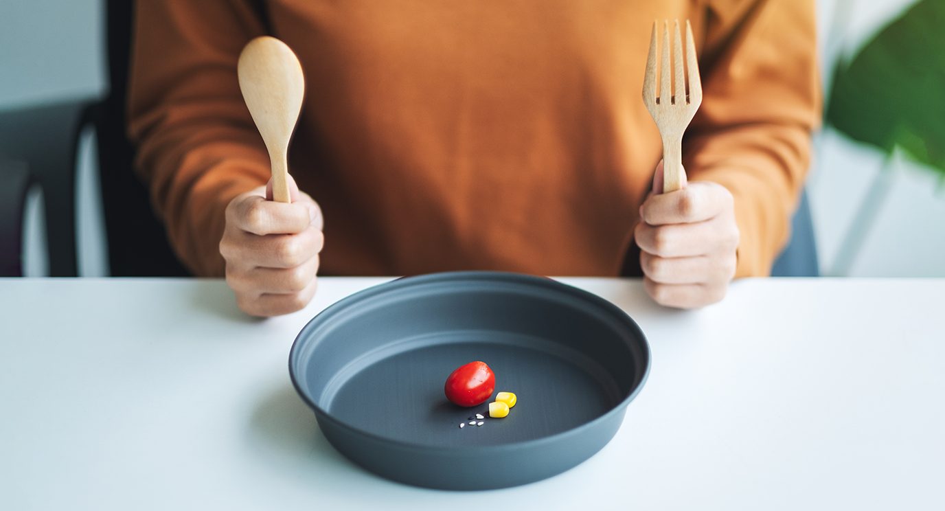 Close-up of dieter's plate with only a few vew small food items on it