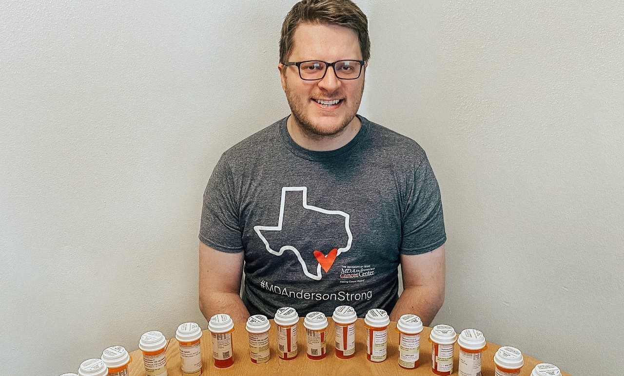 Ethan Damron surrounded by his prescription bottles to celebrate being a chemotherapy survivor.