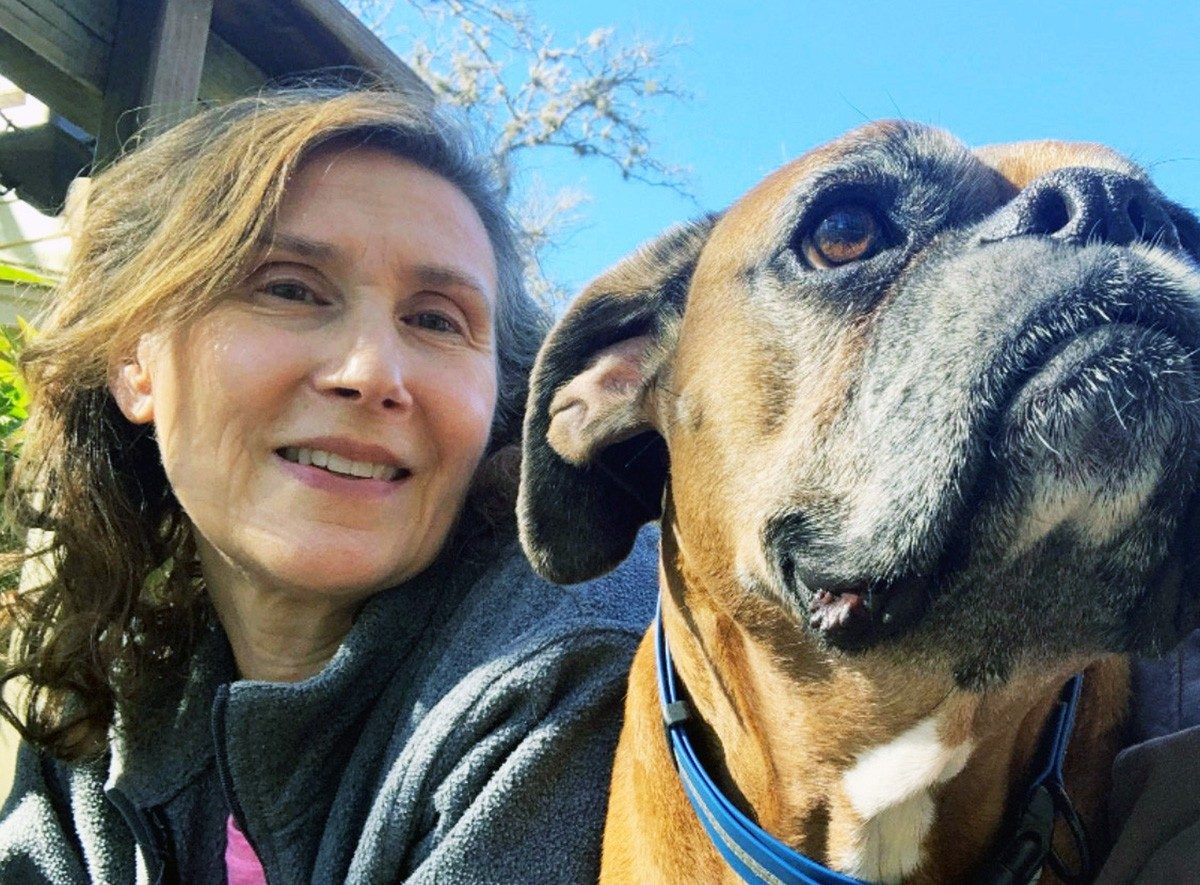 Debbie Schneider sitting outside with her dog.