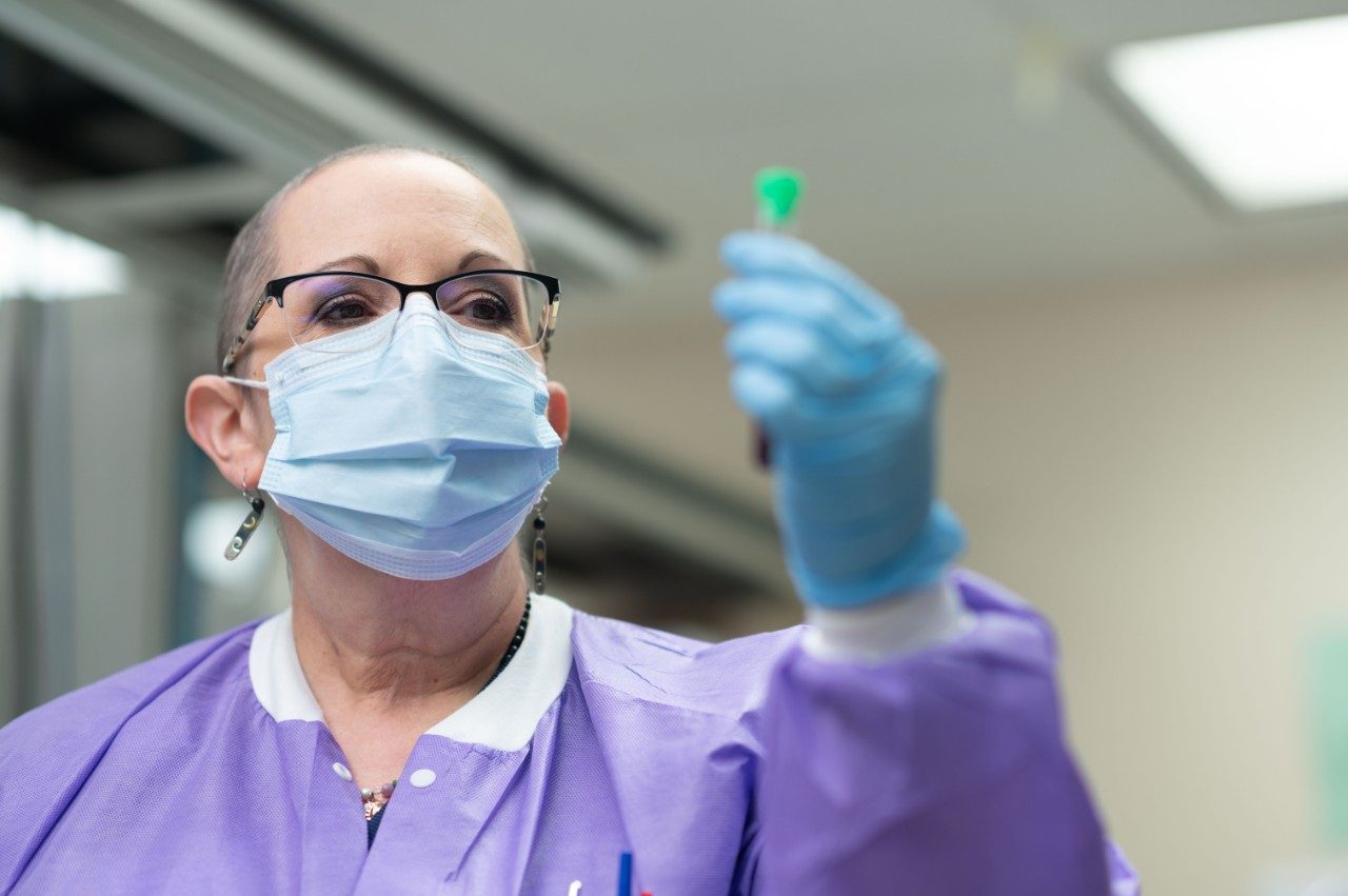 Medical laboratory scientist Carolyn Kleiman examines a test tube in the lab.