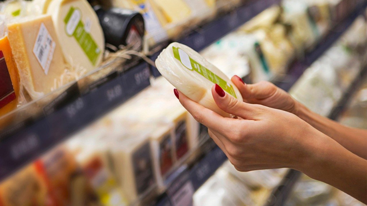 woman looking at cheese in a grocery store